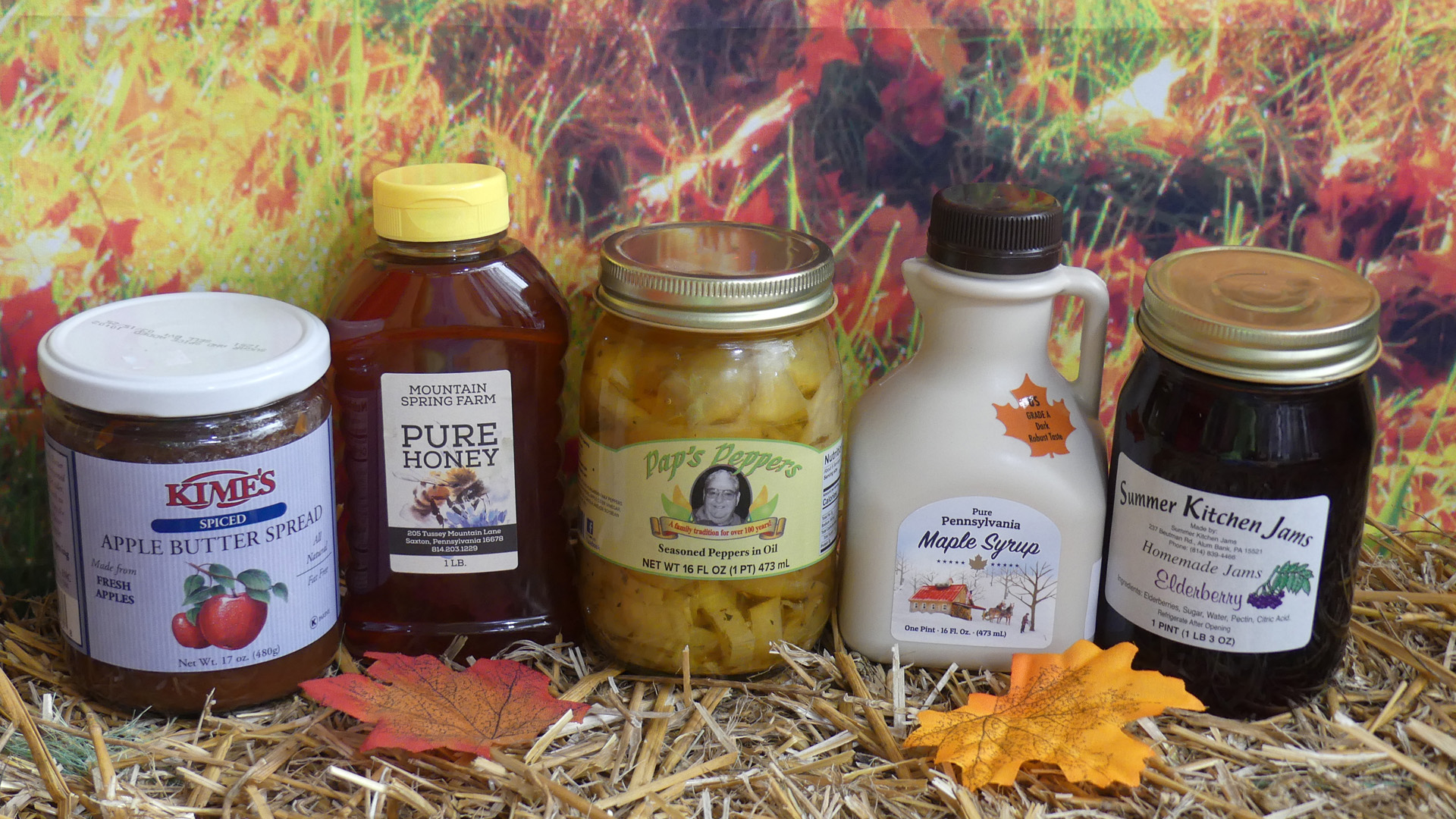 Local products siting on straw with an autumn-themed background